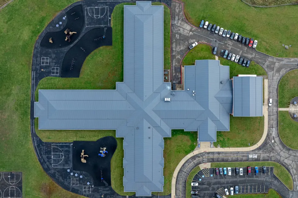 Top-down drone view of the cross-shaped blue-grey metal roof on the Martins Ferry school campus